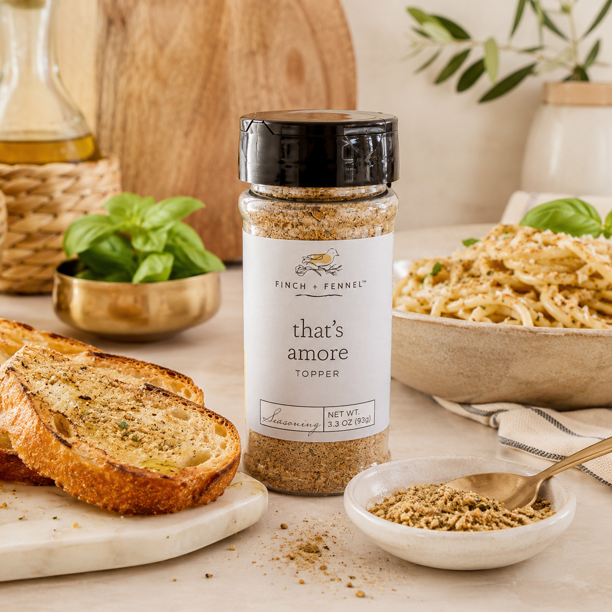 Finch and Fennel That’s Amore seasoning topper styled with garlic bread, pasta, basil, and olive oil.
